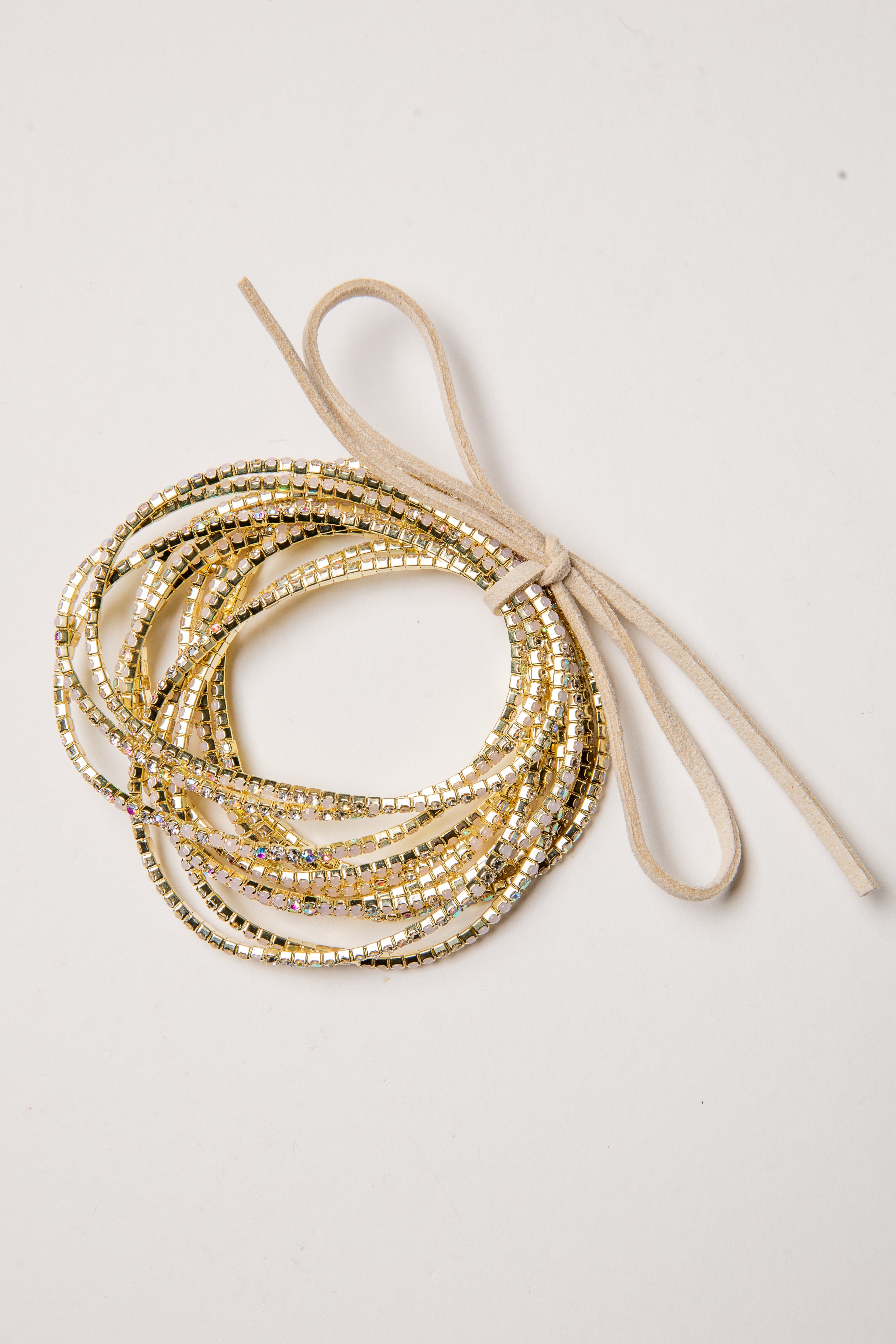 Stack of gold beaded bracelets on a light background