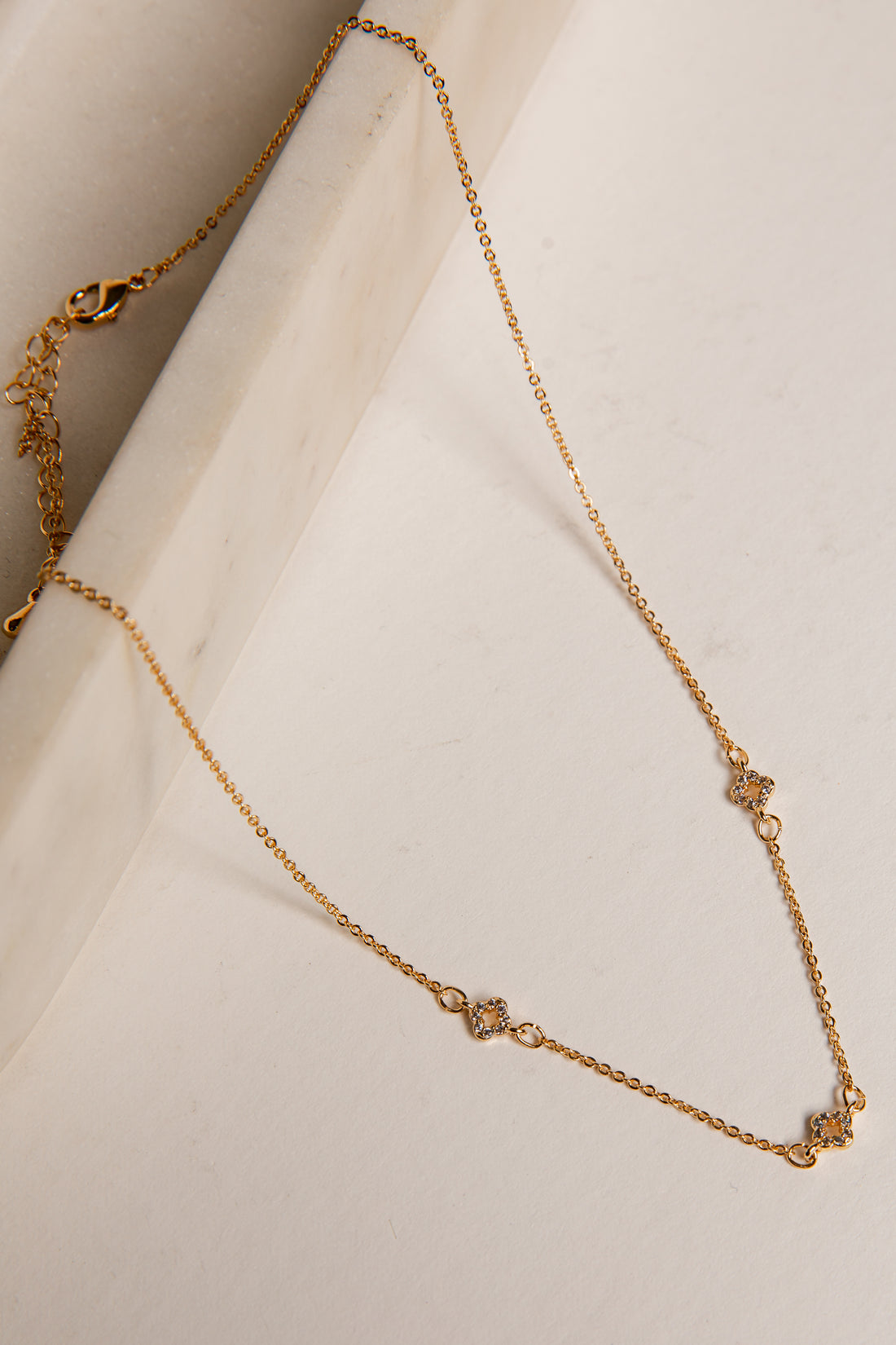 Gold necklace on a white surface