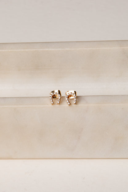 Rose gold elephant earrings on a beige background