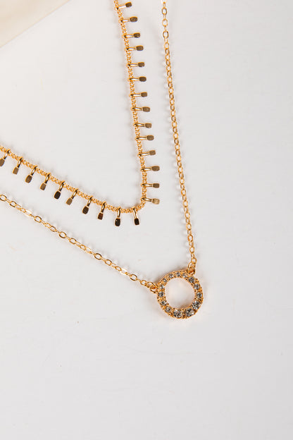 Two gold necklaces on a light gray background