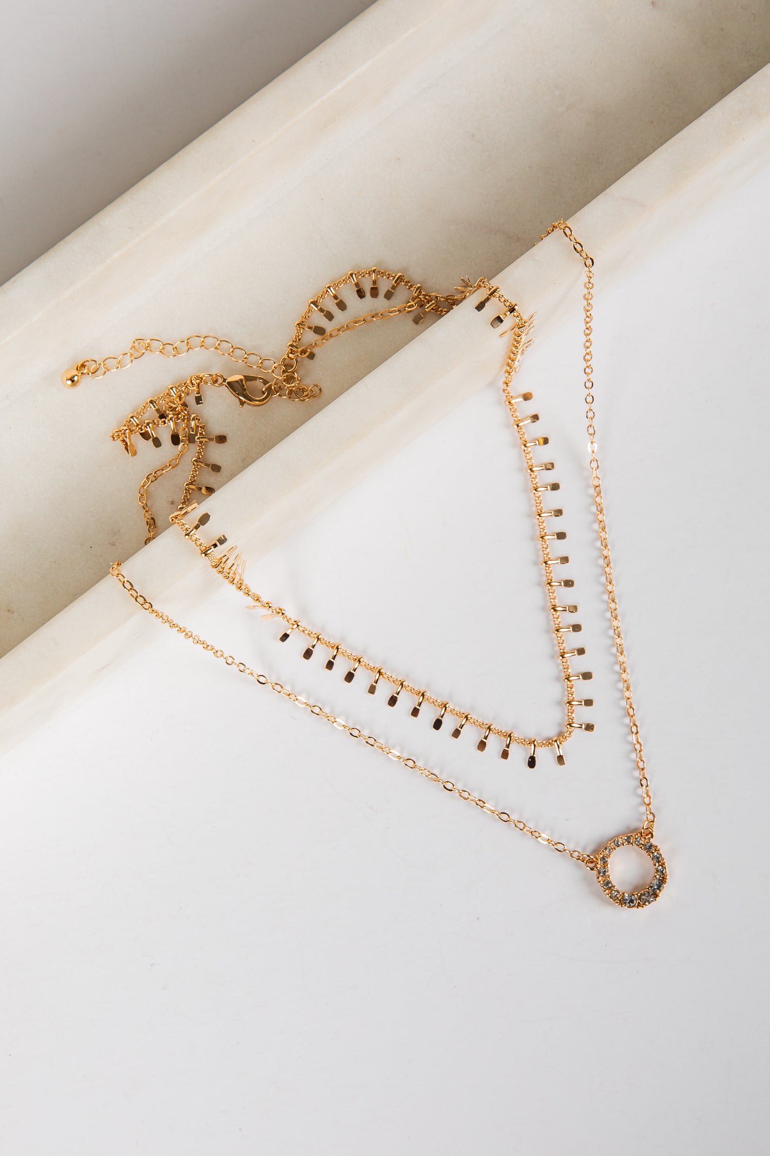 Gold necklaces on a white surface