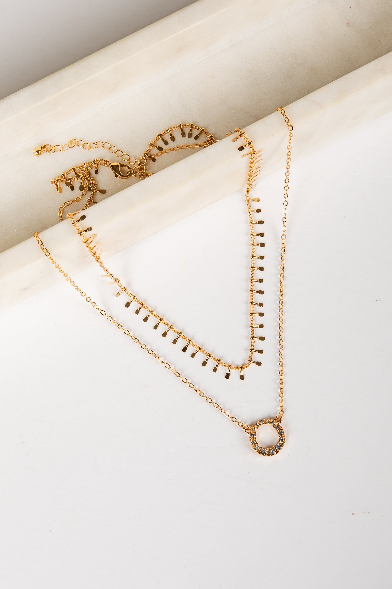 Gold necklaces on a white surface