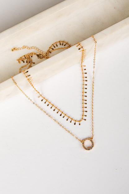 Gold necklaces on a white surface