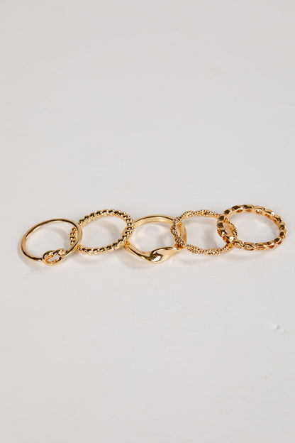 Set of gold rings on a light gray background