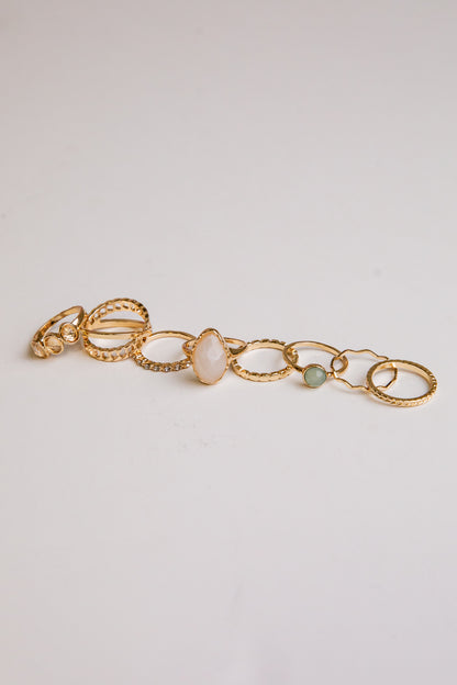 Gold bracelet with circular links and stones on a light gray background