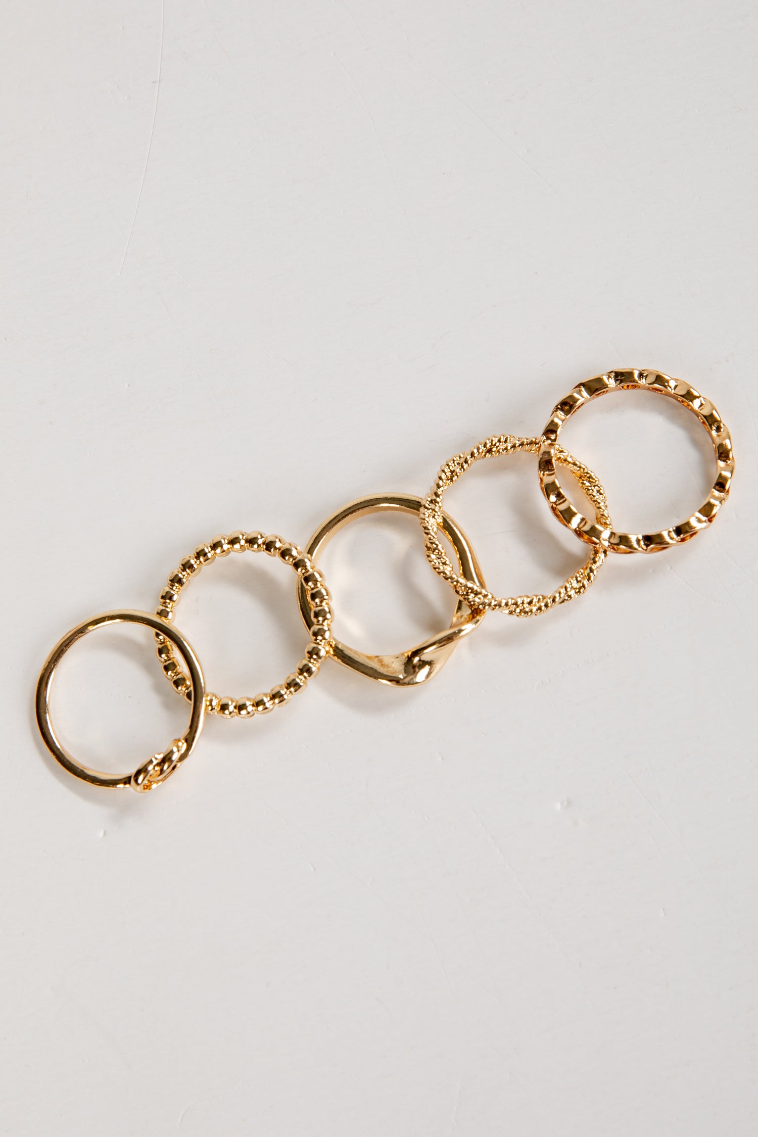 Gold ring with multiple interconnected rings on a light gray background