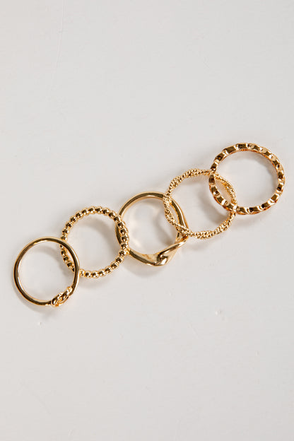 Gold ring with multiple interconnected rings on a light gray background