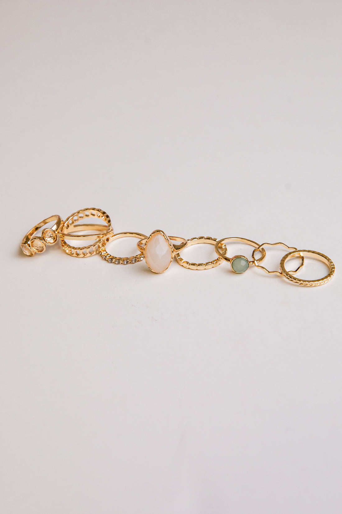 Gold bracelet with stones on a light gray background