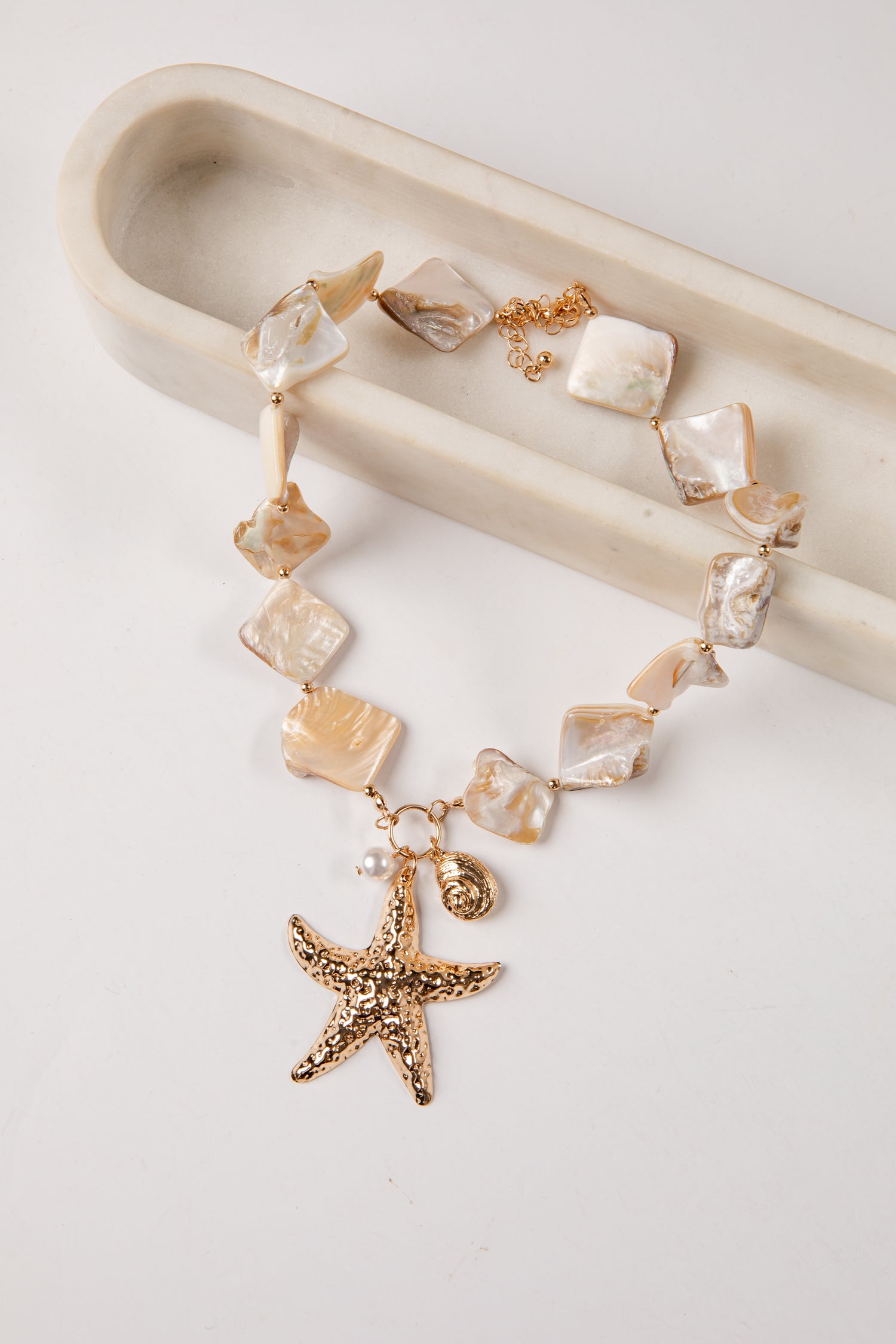 necklace with starfish charm and crystal-like beads on a white background