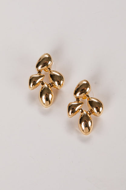 Pair of gold earrings on a light gray background