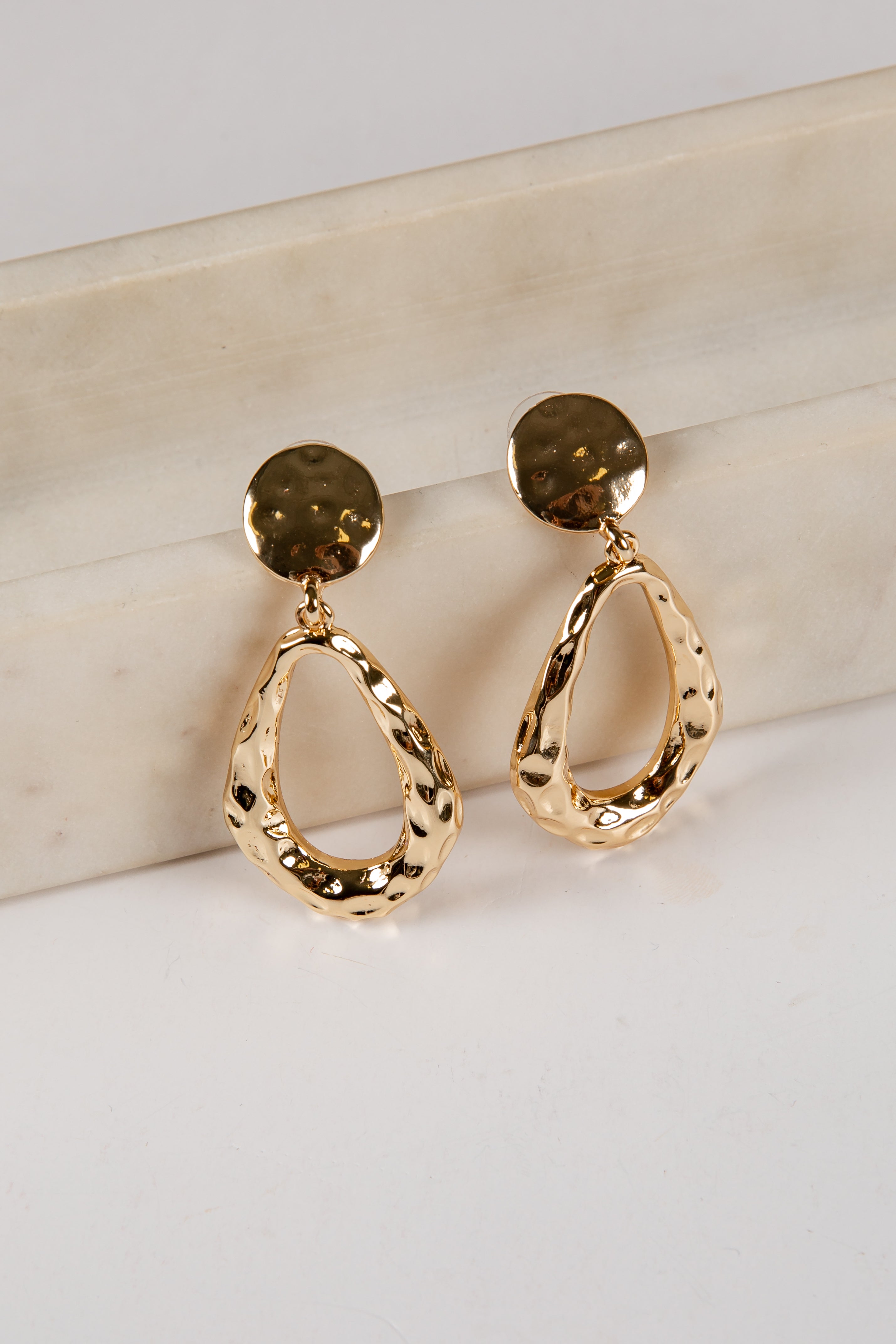 Gold hoop earrings on a light background