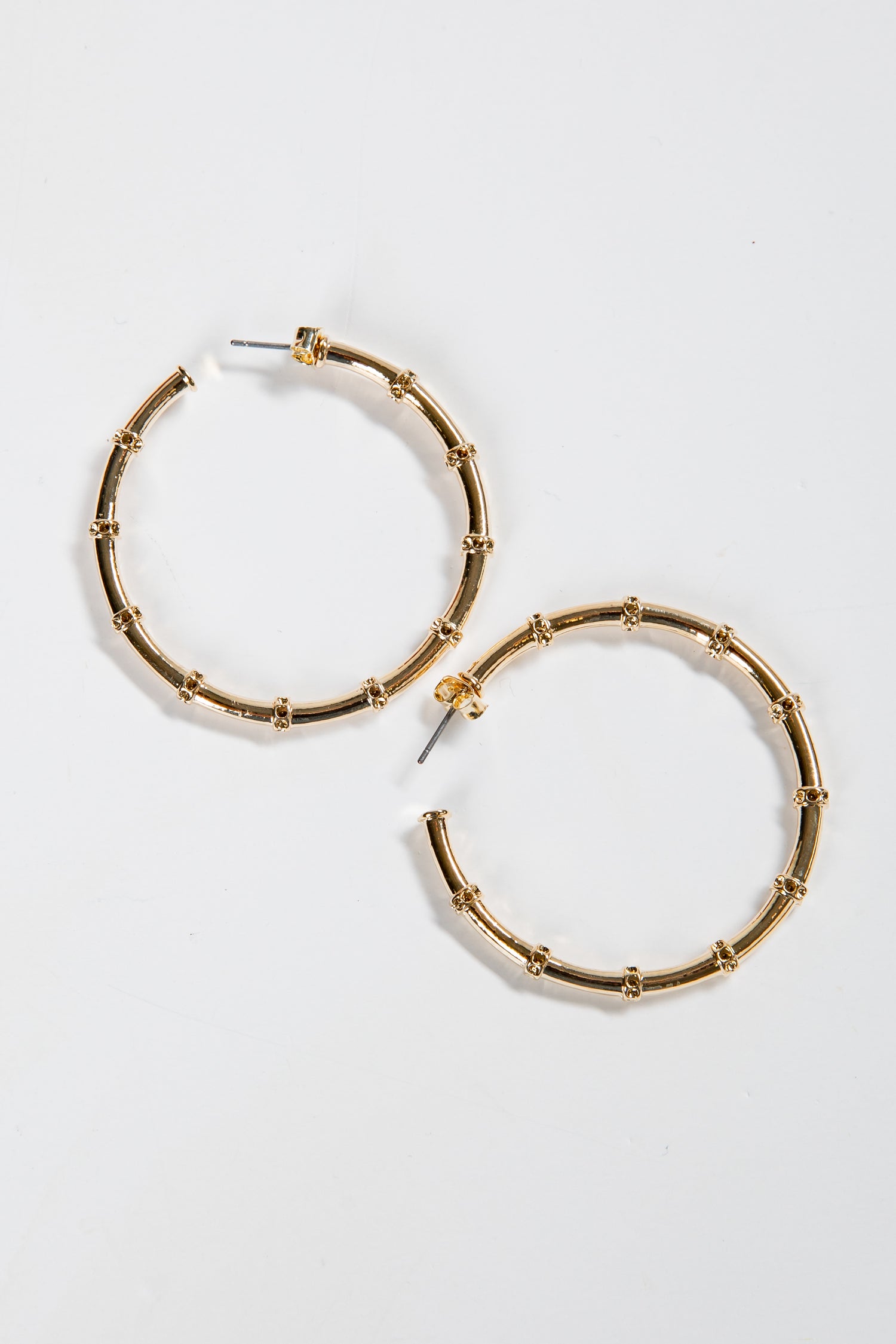Gold hoop earrings on a light gray background