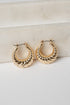 Gold hoop earrings on a light background