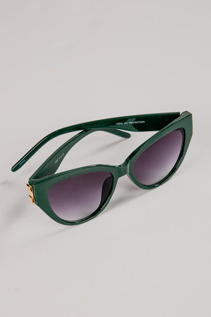 Green sunglasses with dark lenses on a light gray background
