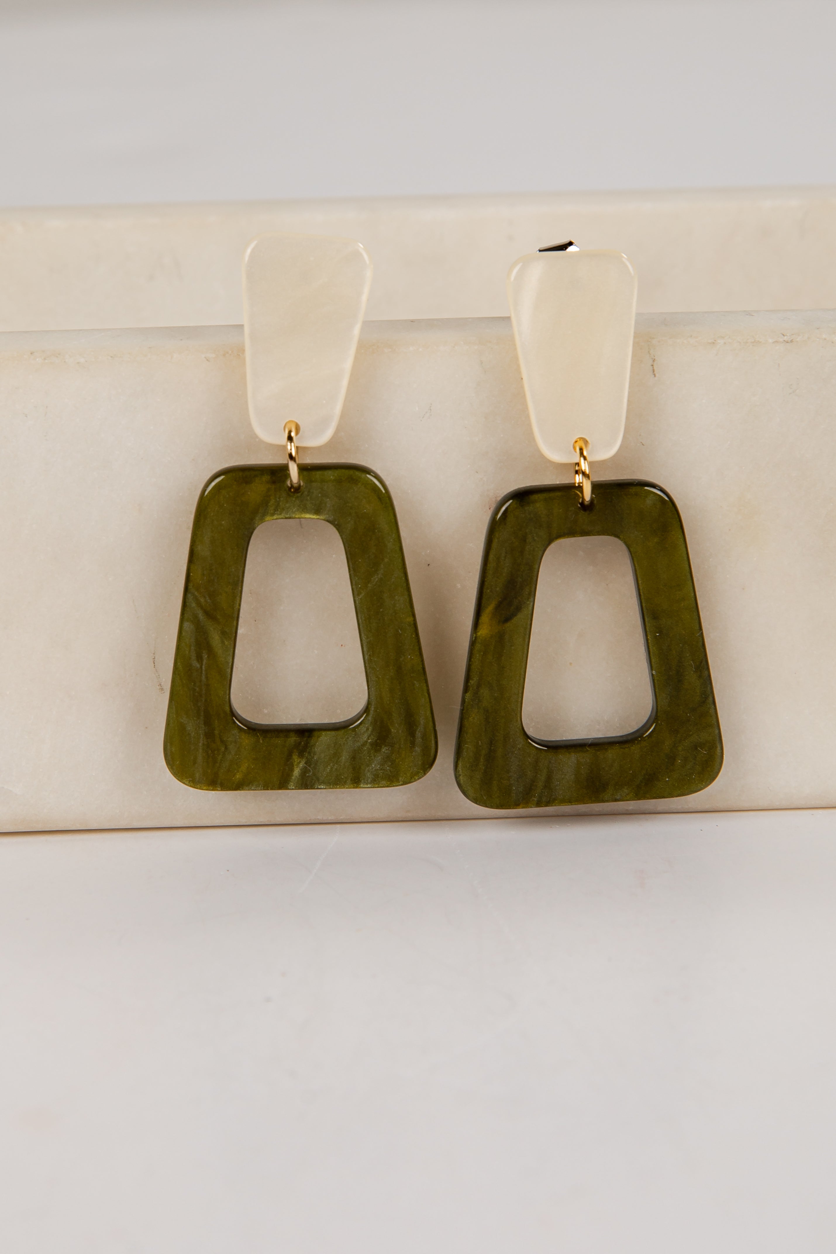 Pair of green square earrings on a white background
