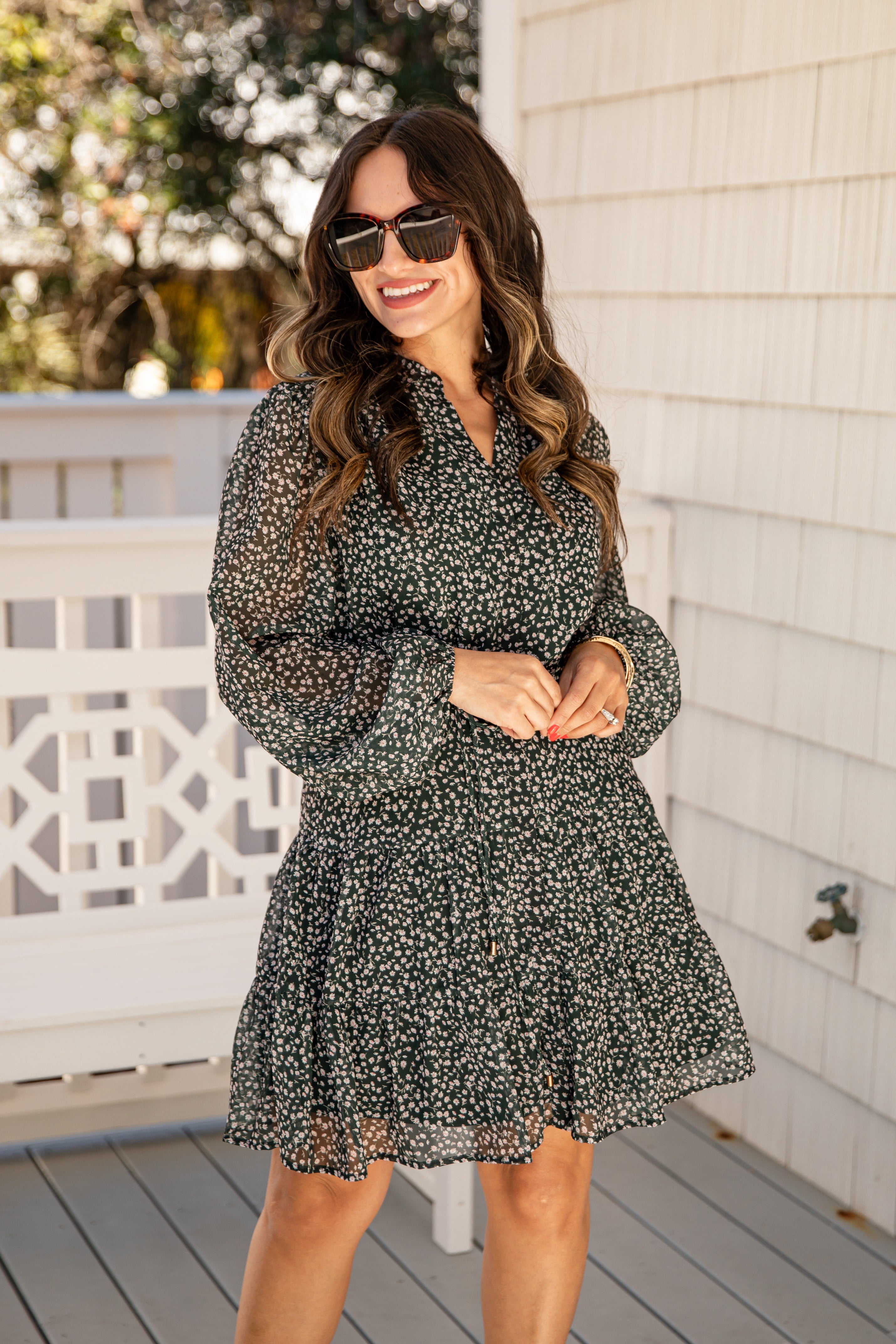 Woman wearing a floral dress on a wooden deck