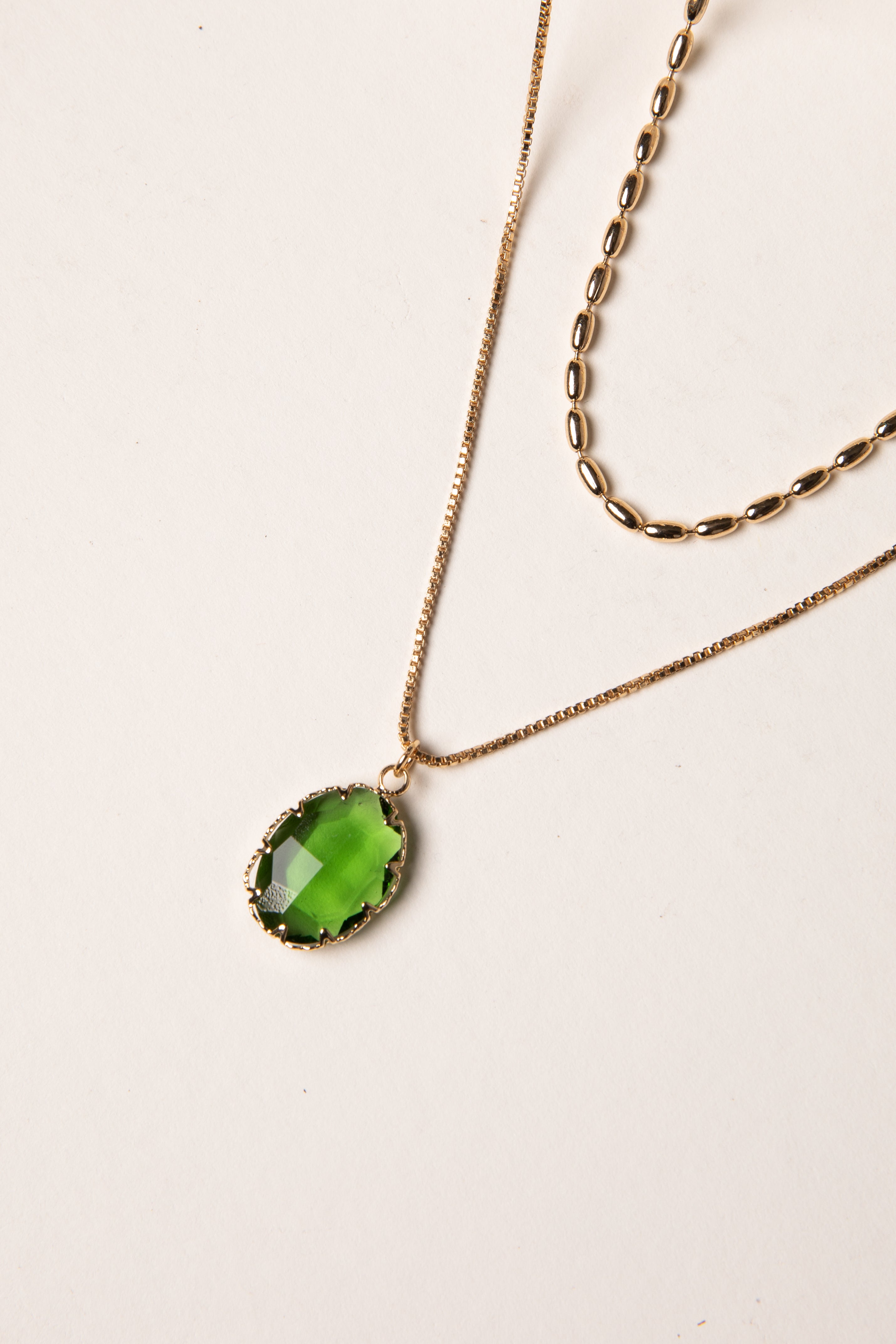 Necklace with a green pendant on a light background