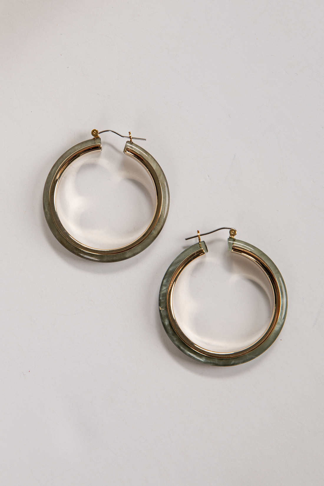 Pair of gold hoop earrings on a light gray background