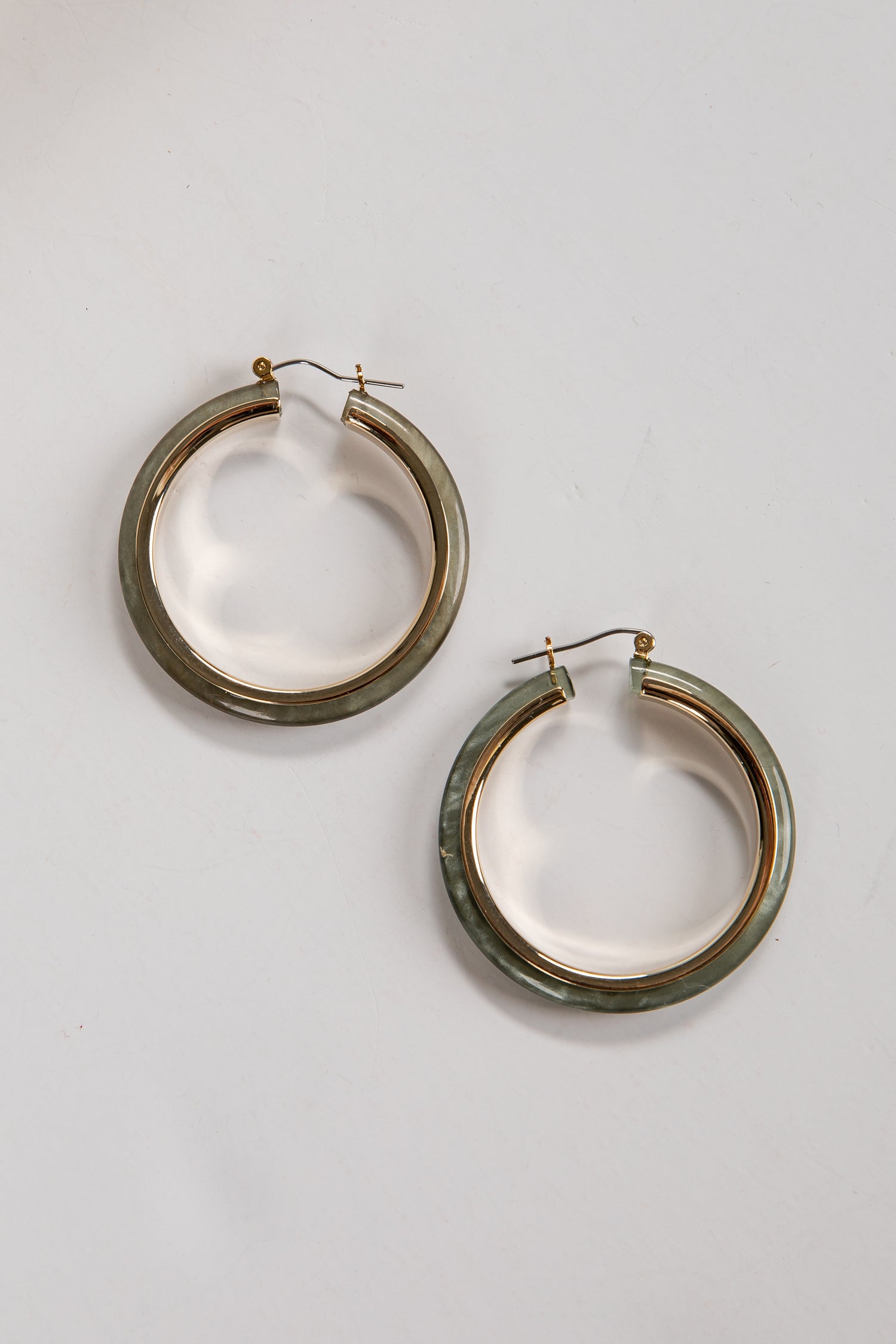 Pair of gold hoop earrings on a light gray background