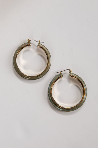 Pair of gold hoop earrings on a light gray background