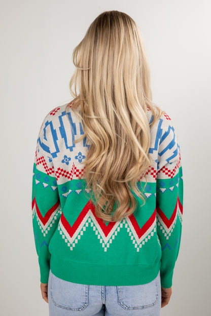 Person wearing a colorful patterned sweater with a plain background