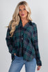Woman wearing a green plaid shirt and blue jeans on a white background
