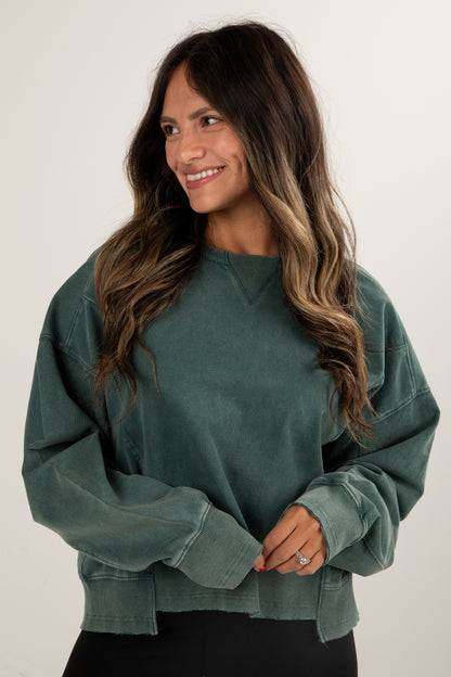 Woman wearing a green sweater against a white background