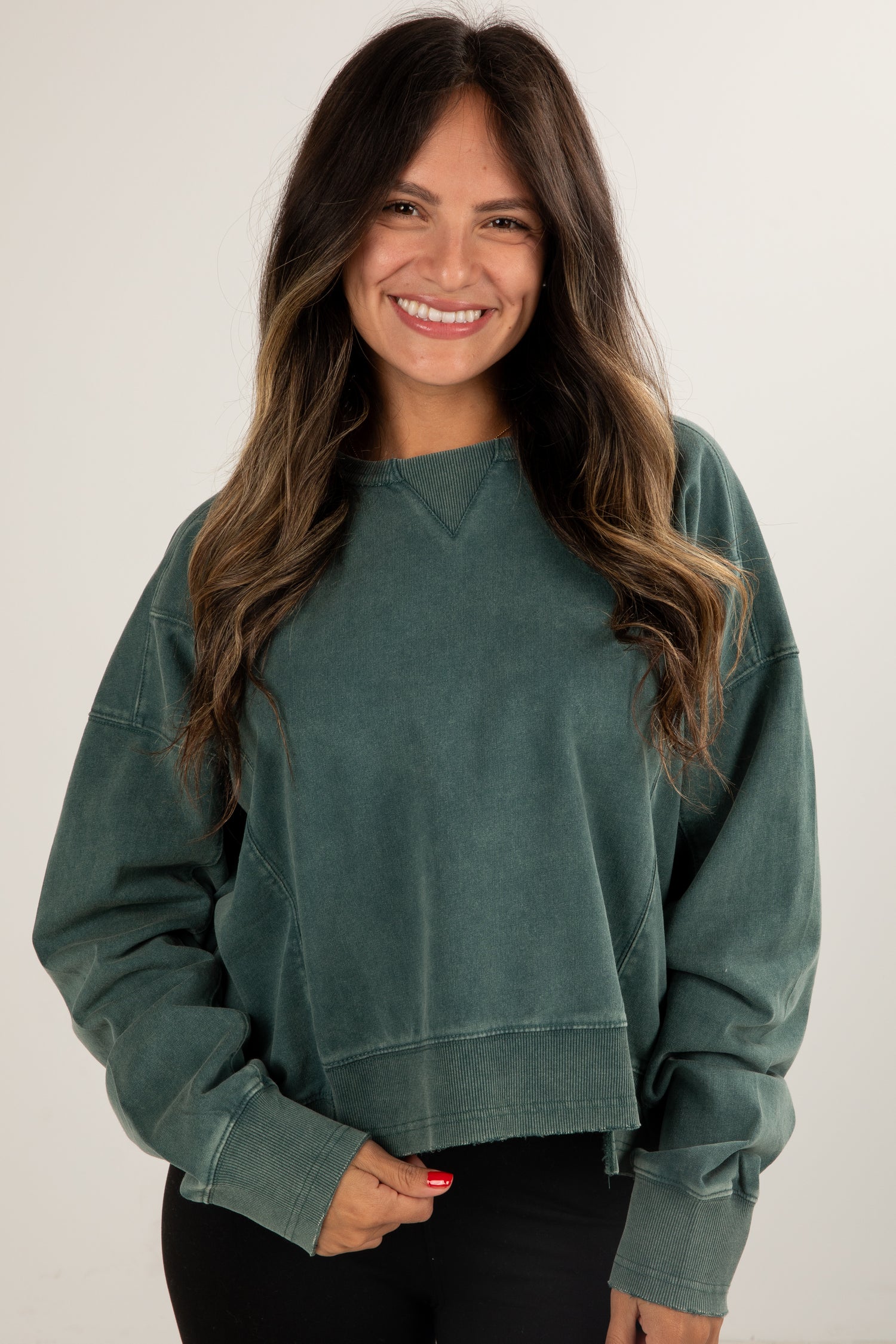 Woman wearing a green sweatshirt against a white background