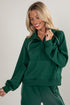 Woman wearing a green tracksuit against a plain background