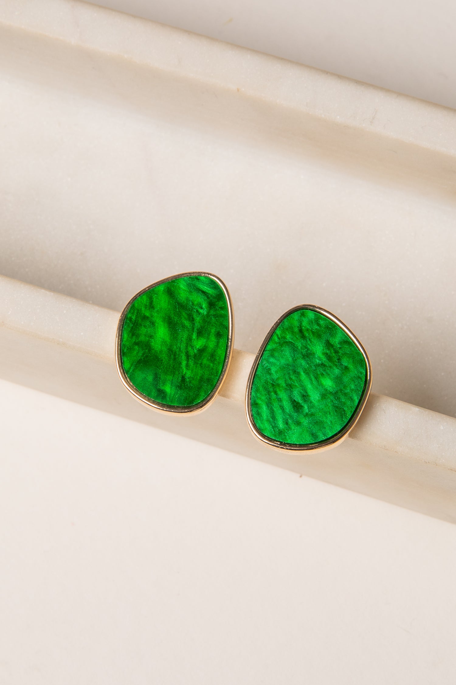 Green teardrop earrings on a white background