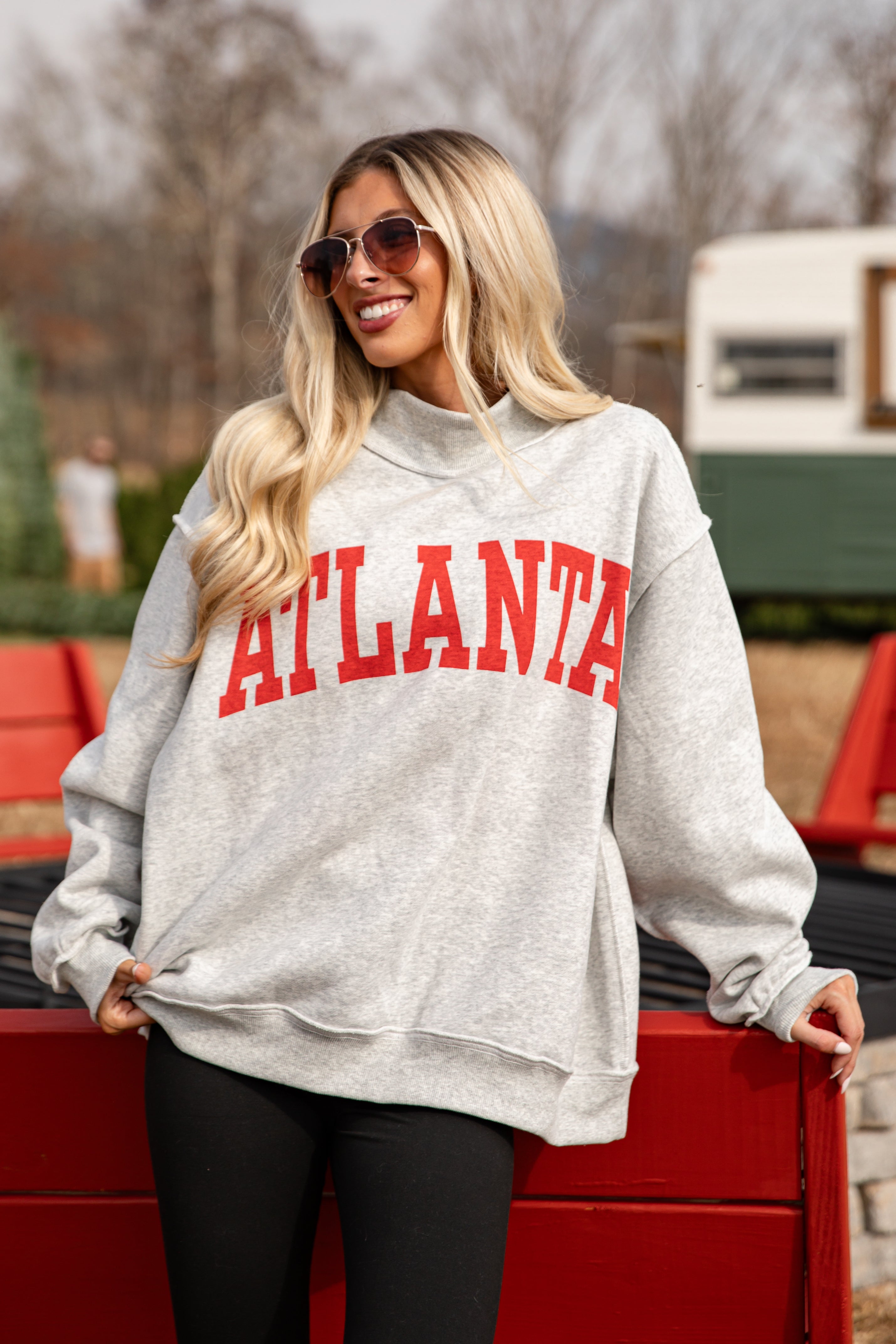 Woman wearing a gray hoodie with &