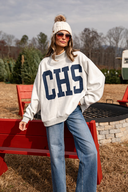 Person wearing a white sweatshirt with &