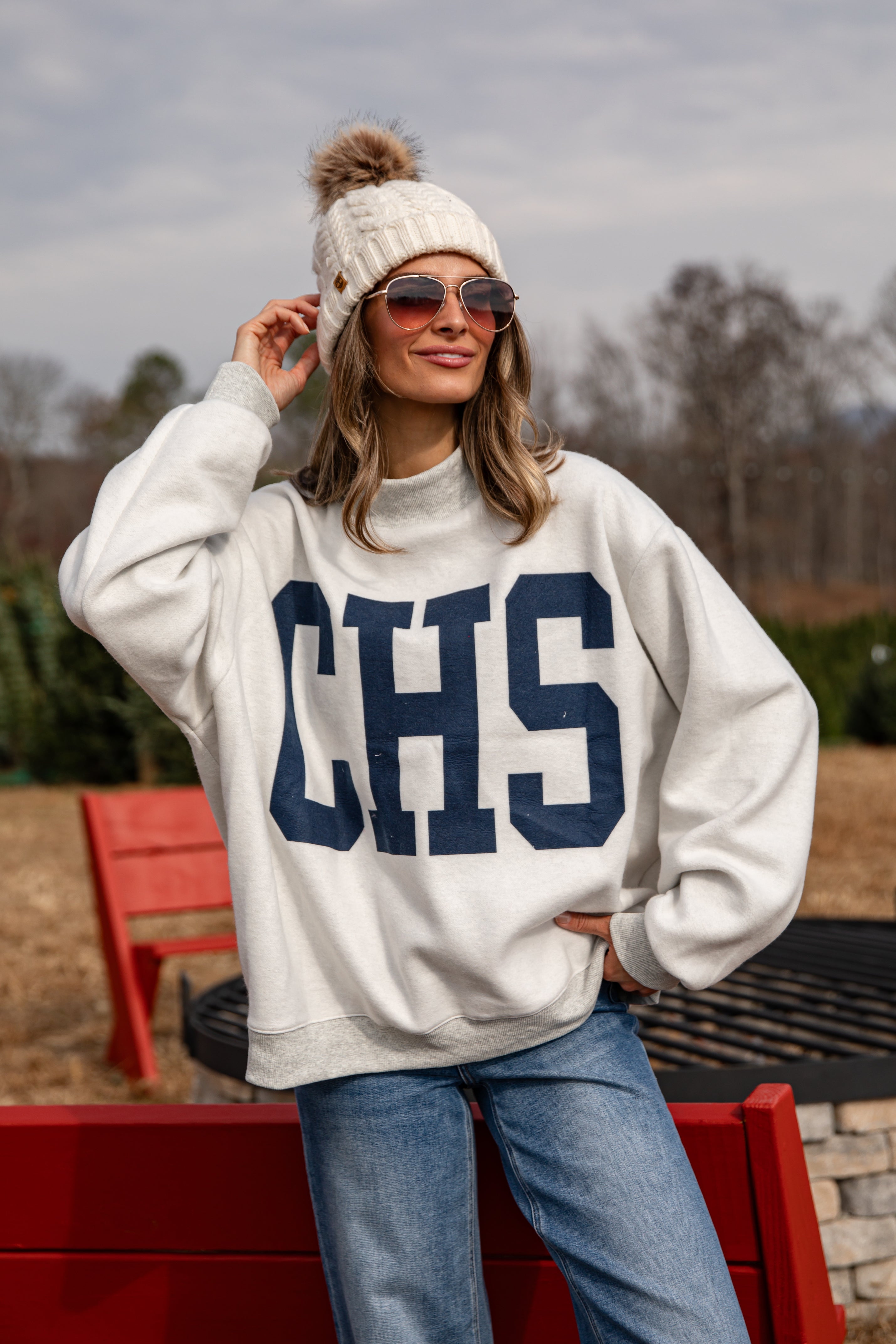 Person wearing a white sweatshirt with &