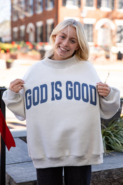 Person wearing a white sweatshirt with &