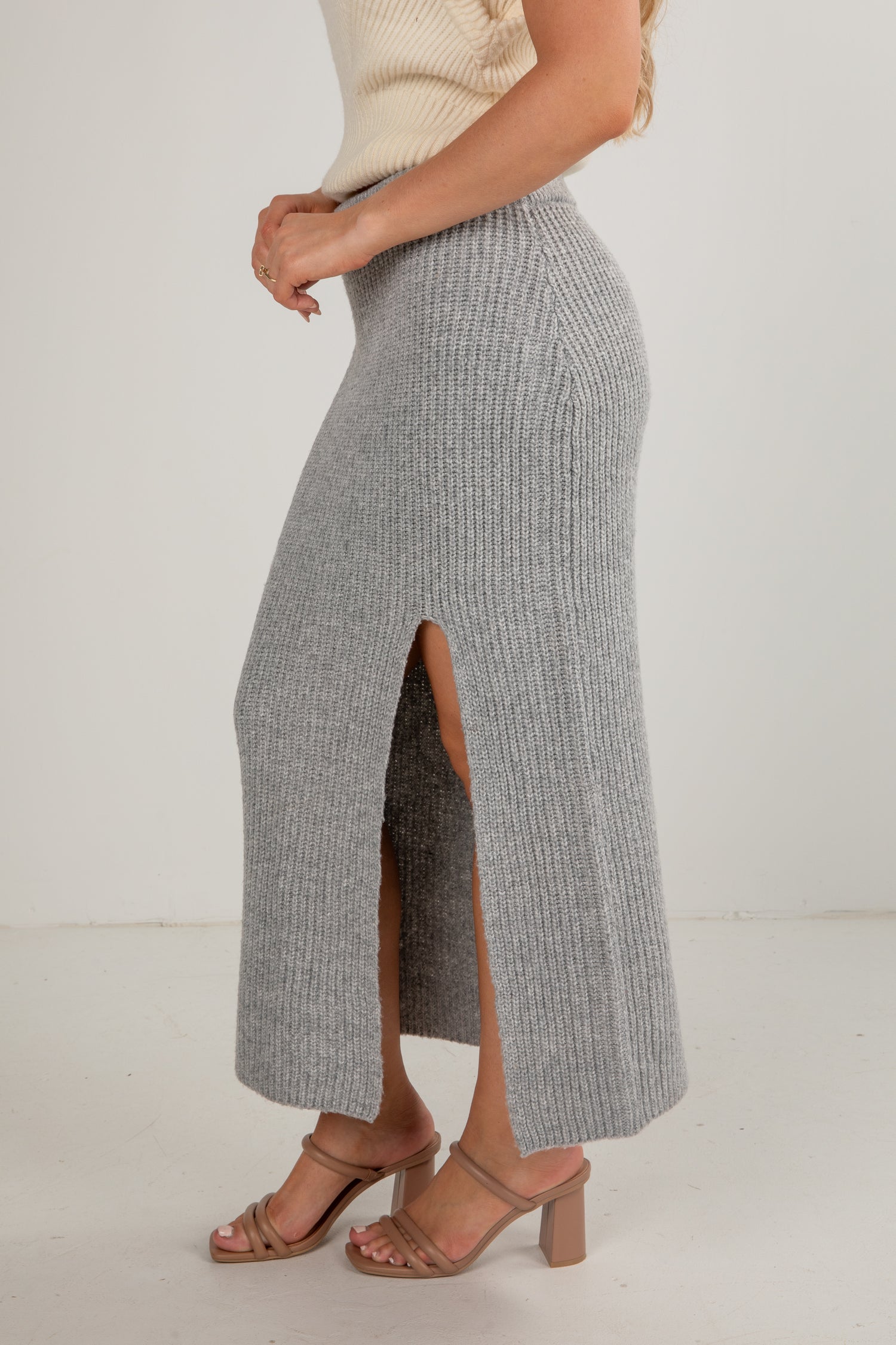 Person wearing a gray checkered skirt with a white background