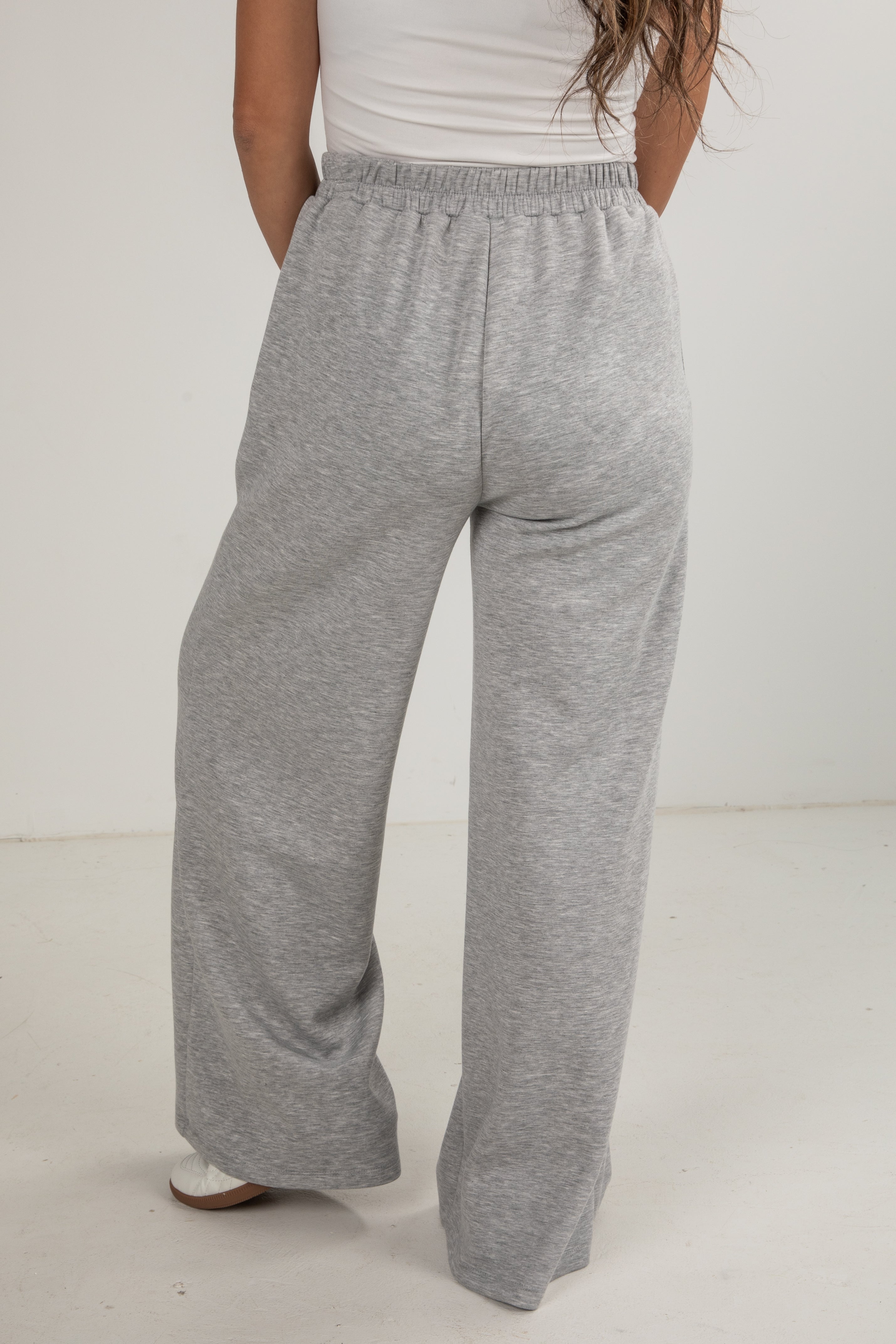 Person wearing gray sweatpants on a white background