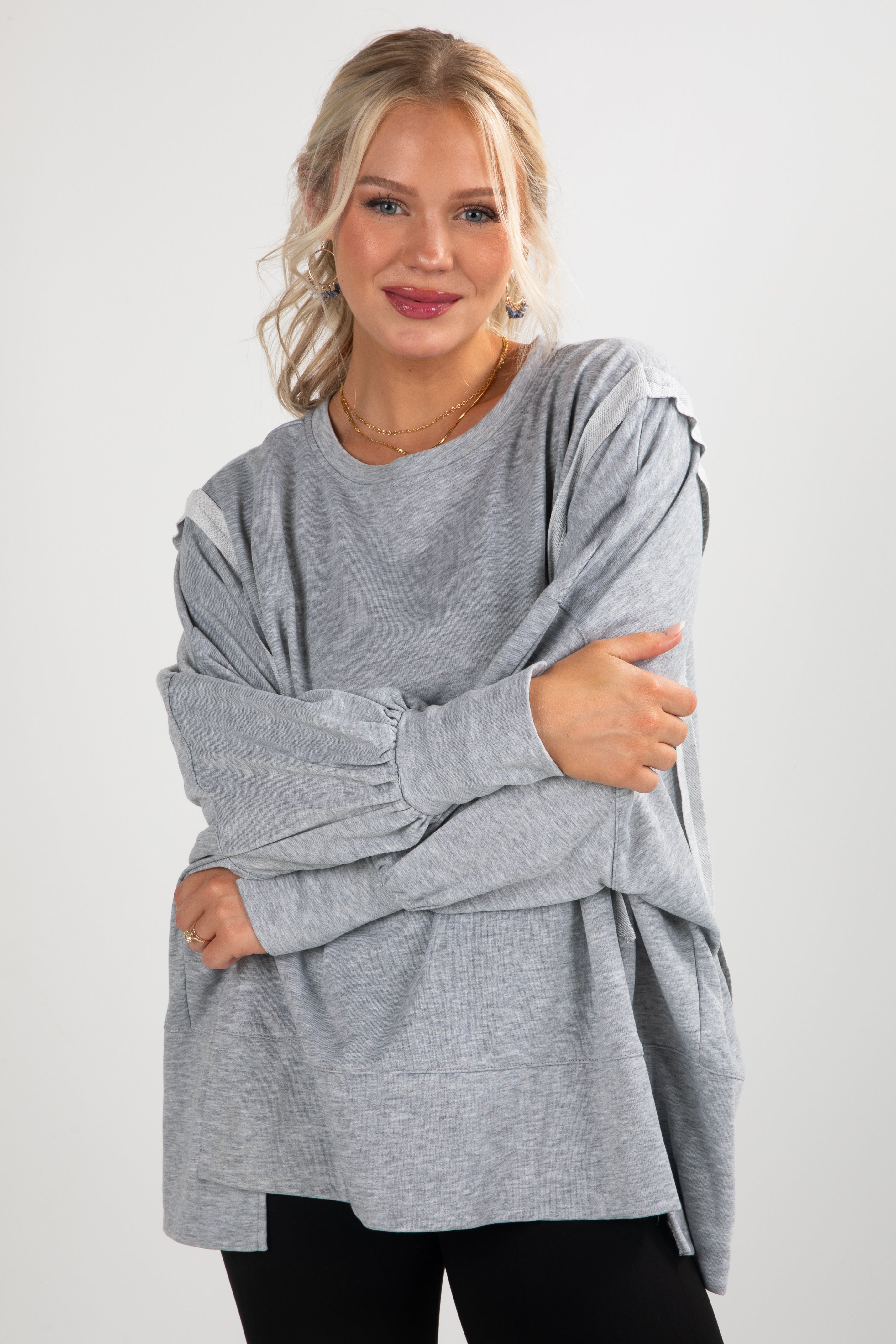 Woman wearing a gray oversized sweater on a white background