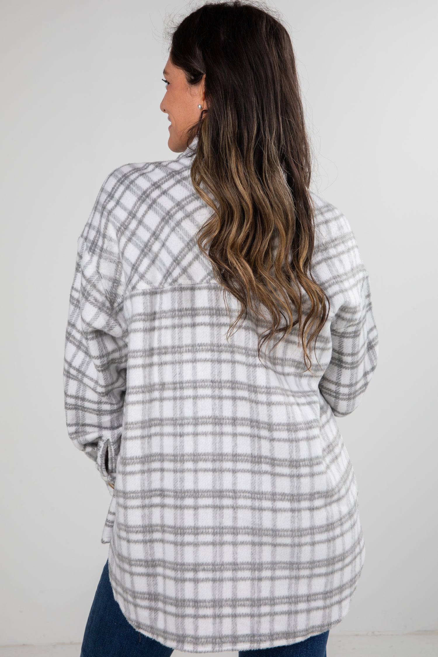 Woman wearing a plaid shirt from behind on a white background