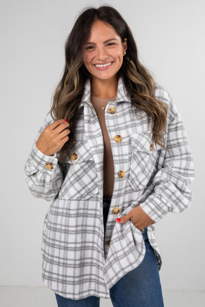 Woman wearing a plaid jacket with a plain background