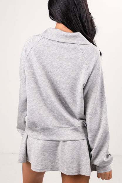 Person wearing a gray tracksuit on a white background
