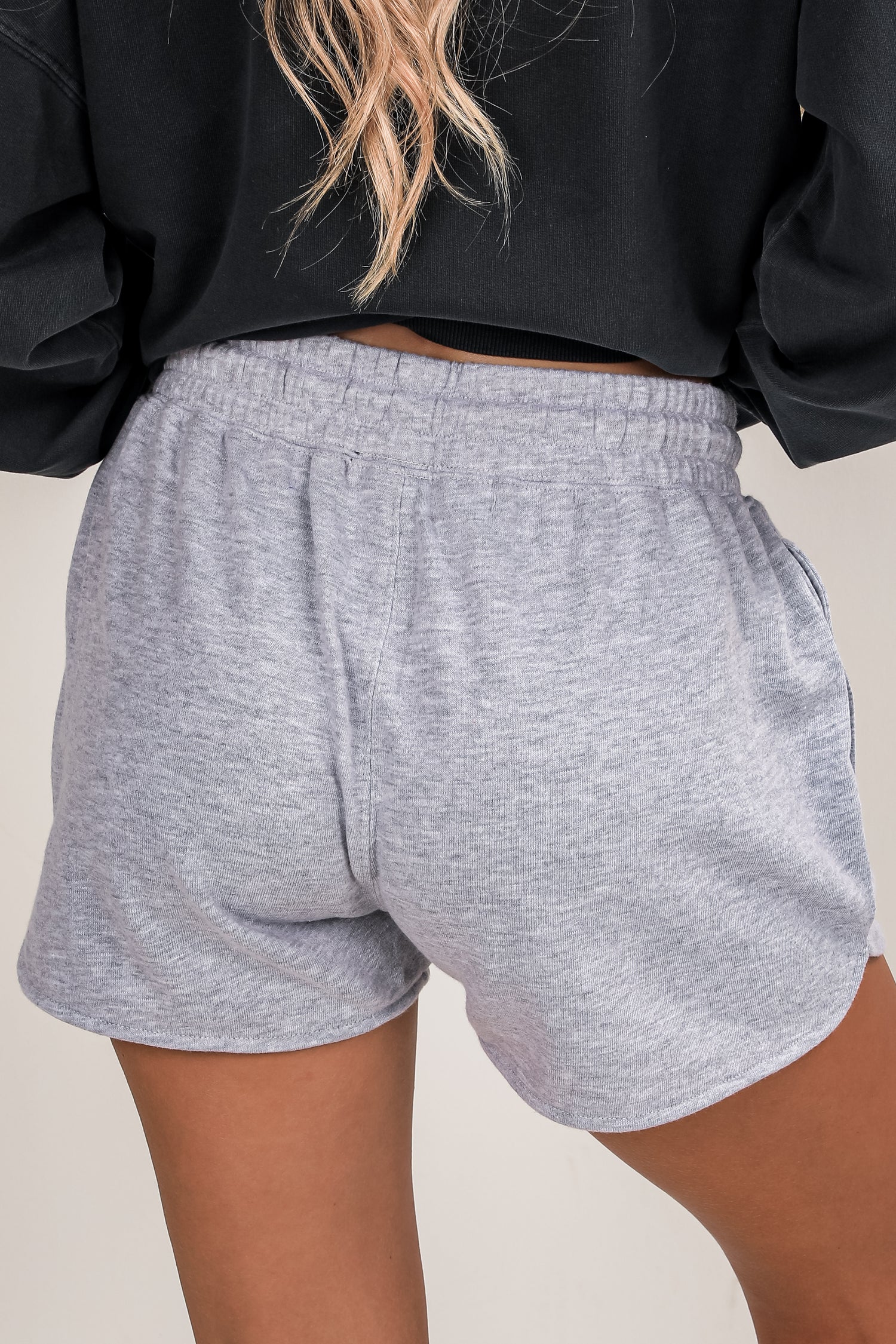 Gray shorts worn by a person on a plain background