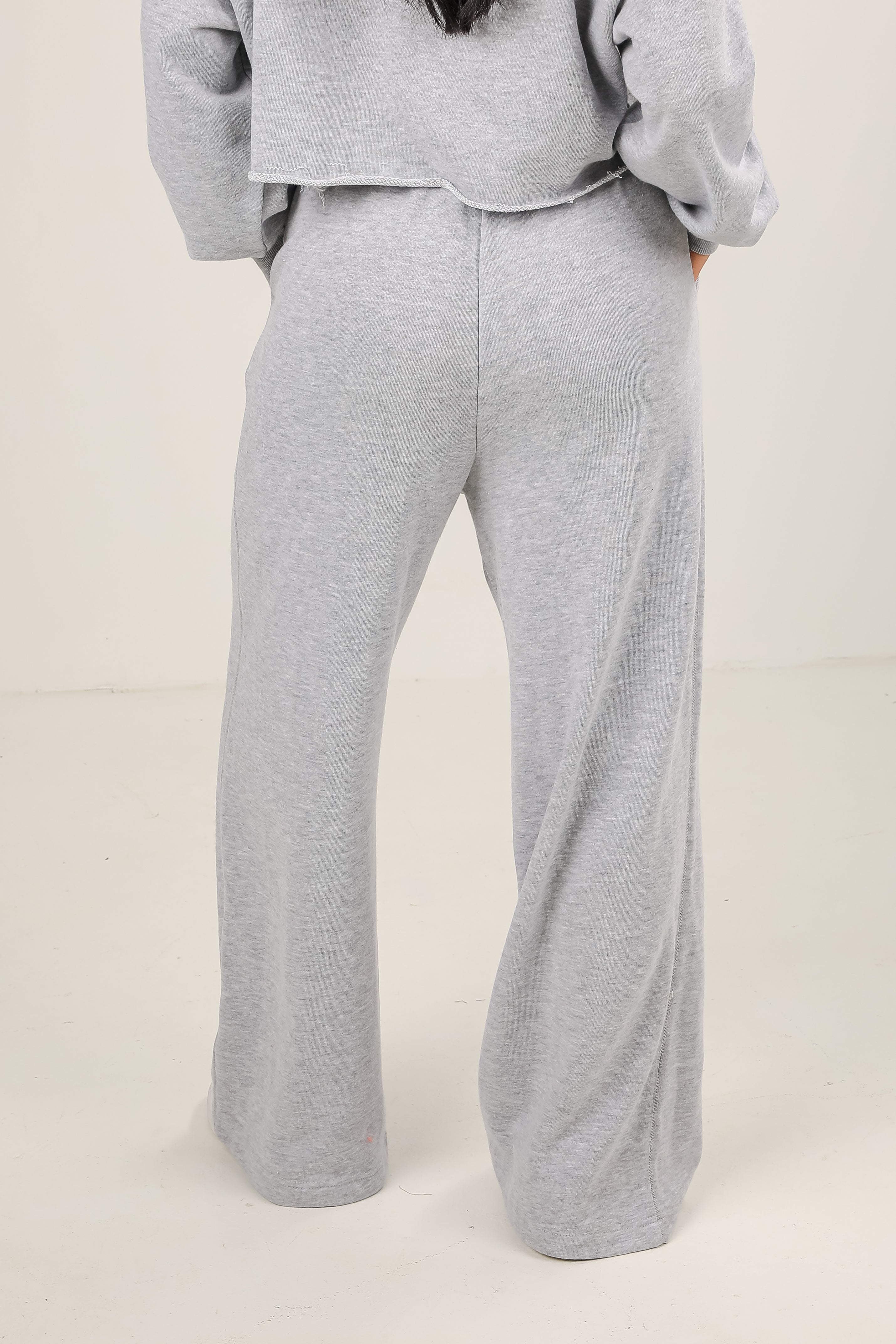 Gray sweatshirt and pants set on a plain background