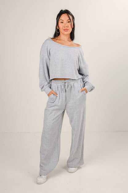 Woman wearing a gray lounge set on a beige background