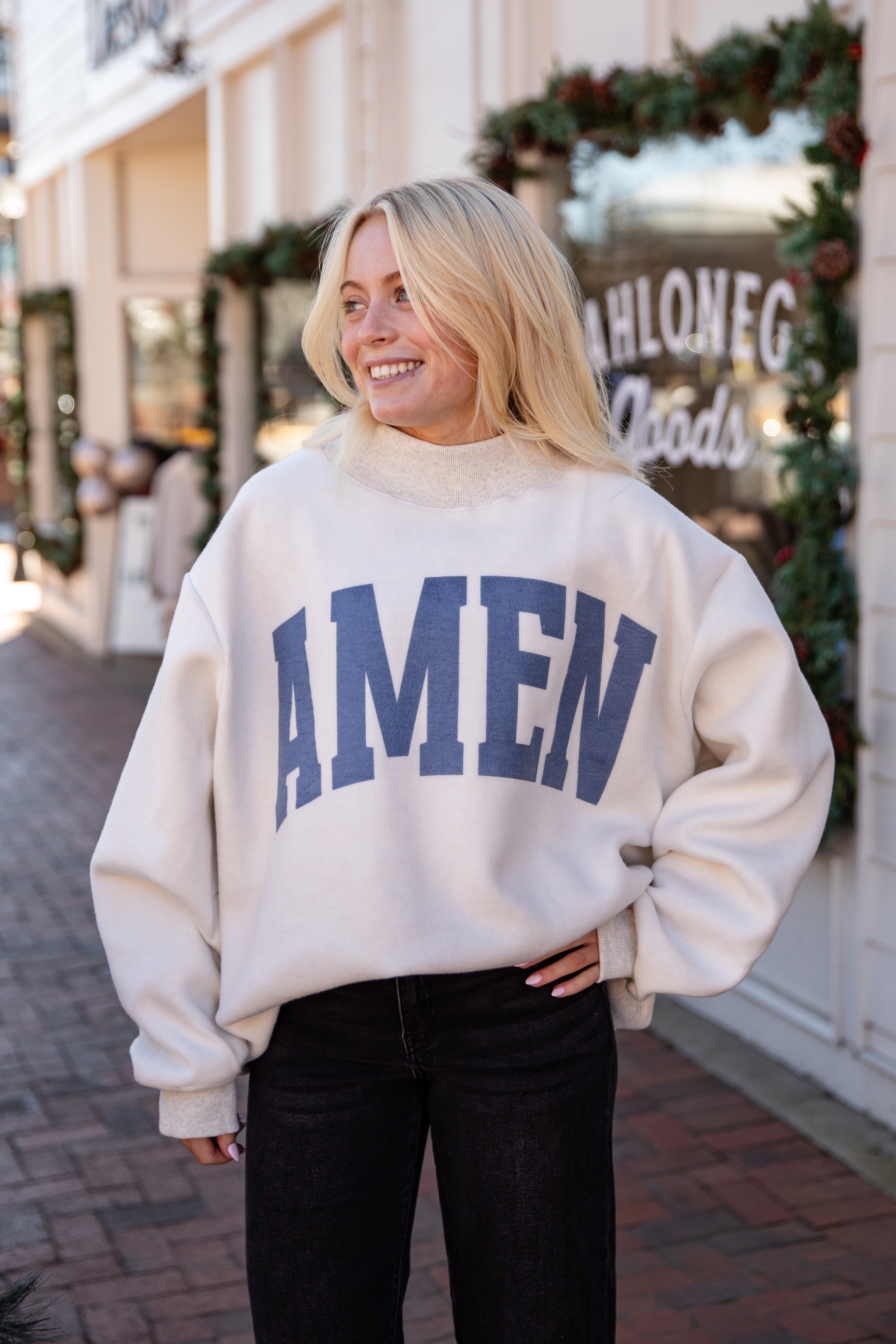 Woman wearing a cream sweatshirt with &