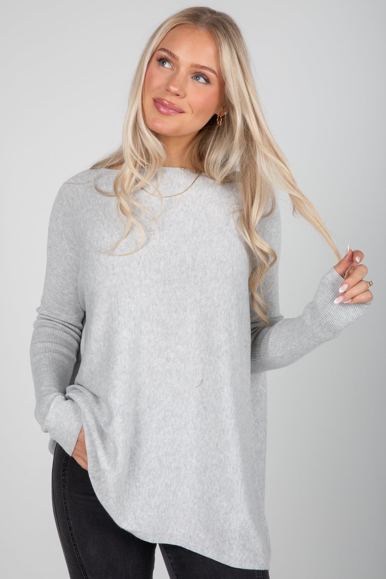 Woman wearing a gray sweater against a plain background