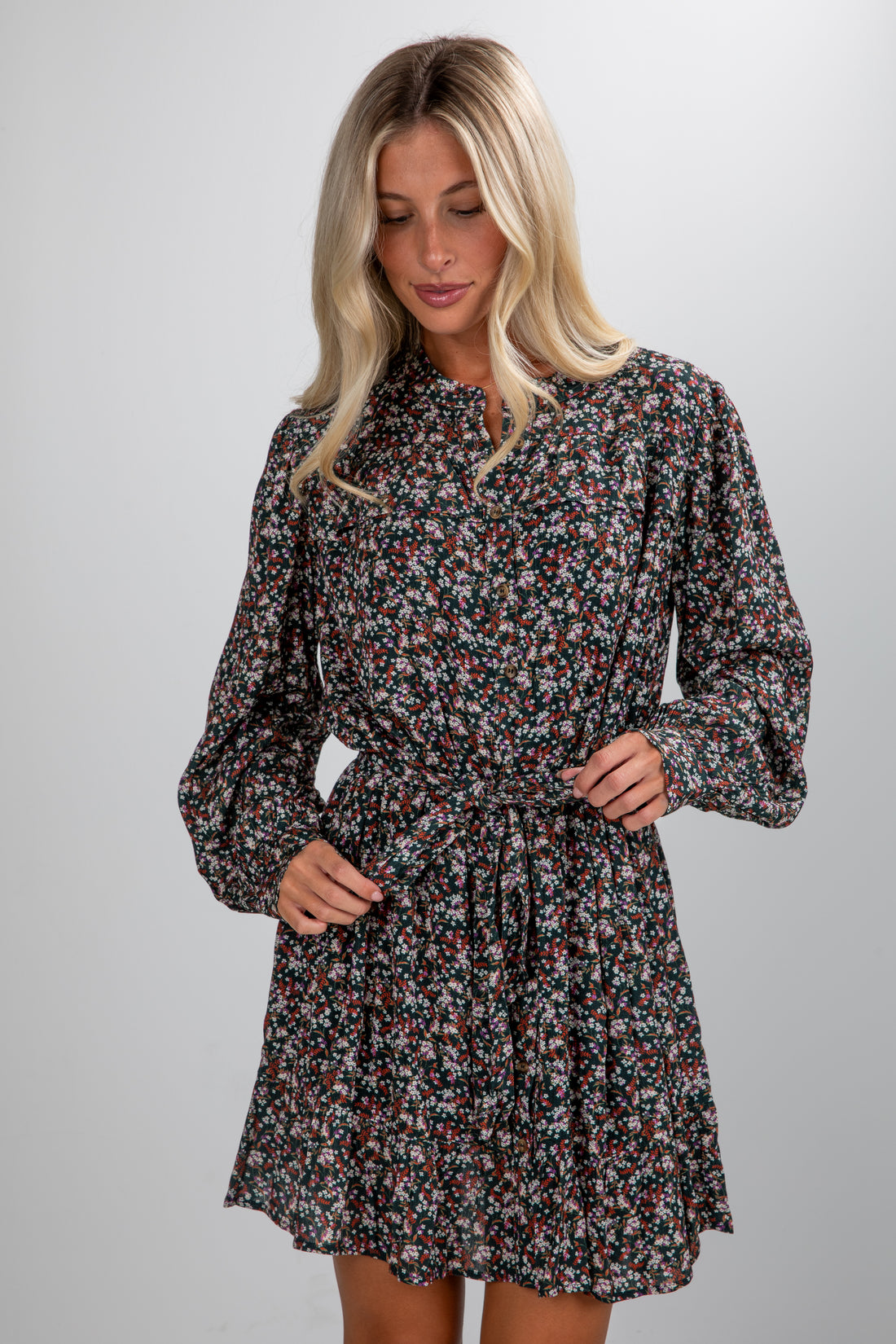 Woman wearing a floral dress against a plain background