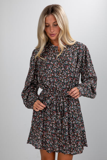 Woman wearing a floral dress against a plain background