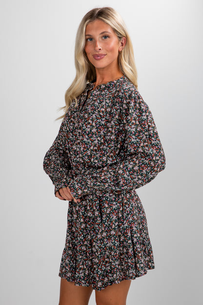 Woman wearing a floral dress against a plain background