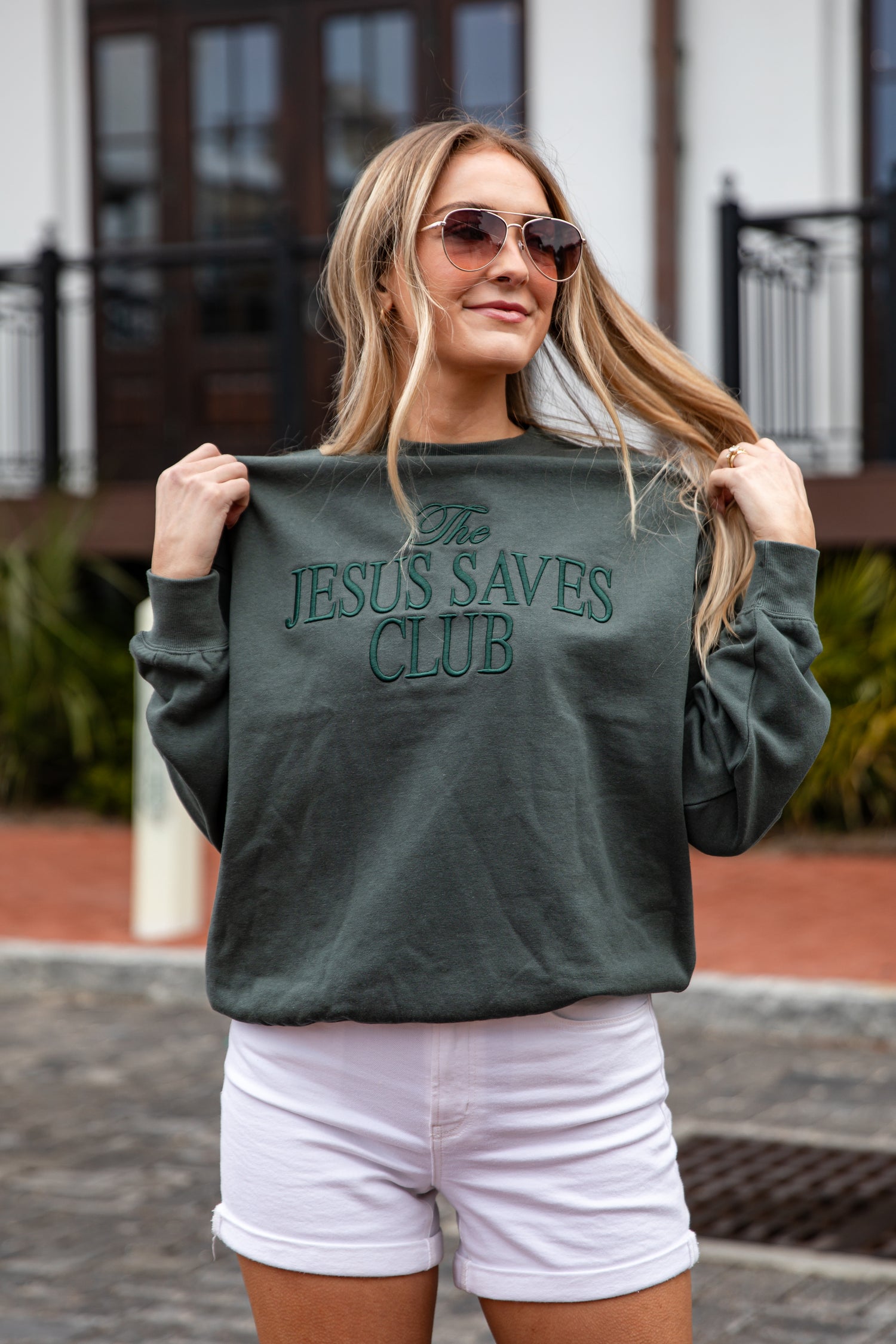 Woman wearing a green sweatshirt with &