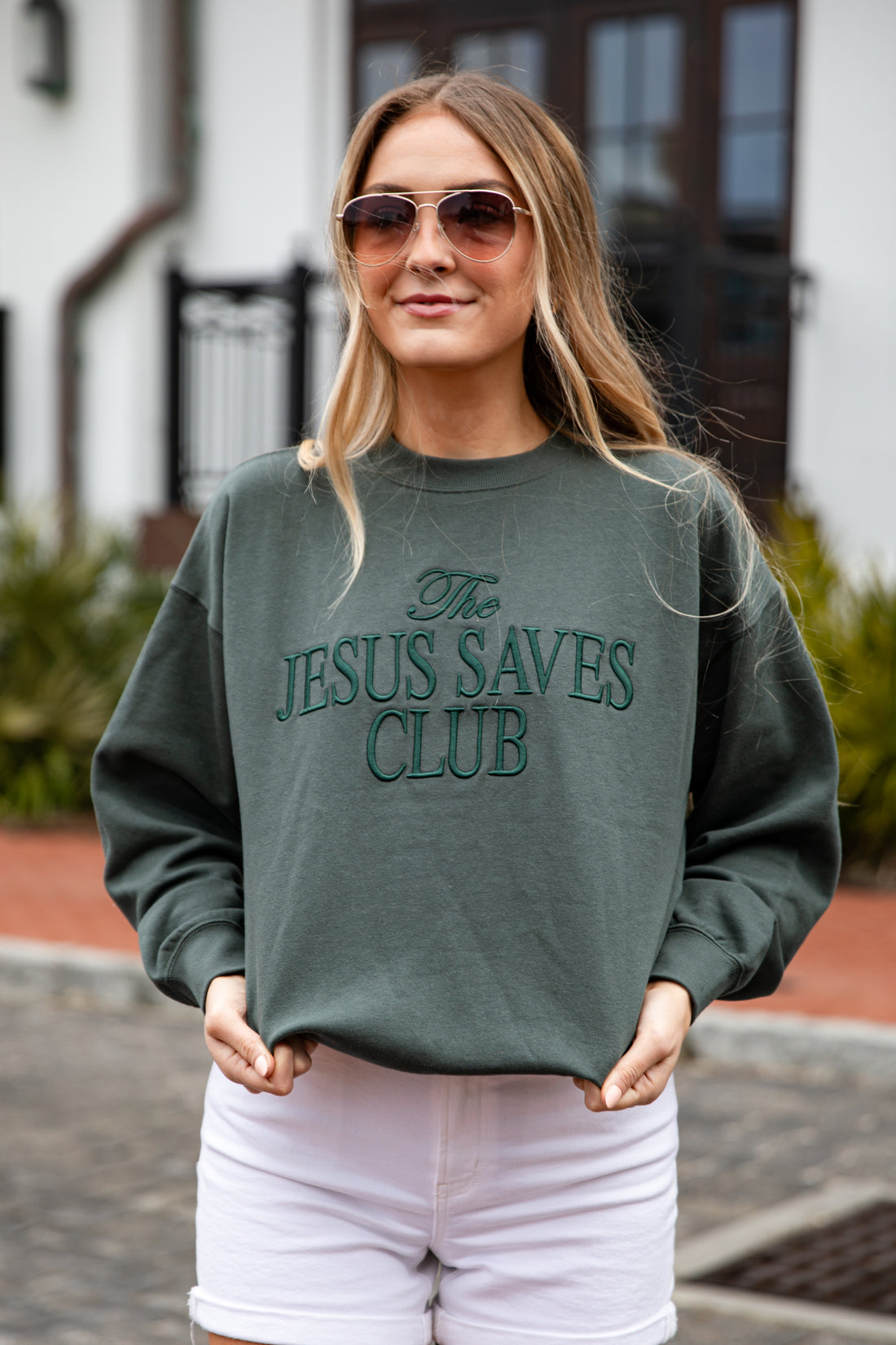 Person wearing a green sweatshirt with &